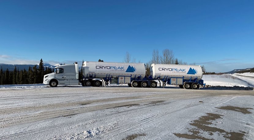 Two large Cryopeak tanks on a semi truck in a snowy setting with blue skies